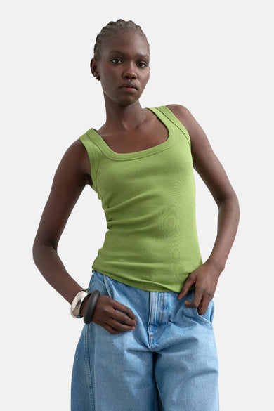 Débardeur vert TOPSHOP à texture côtelée, porté avec un jean et un bracelet argenté.