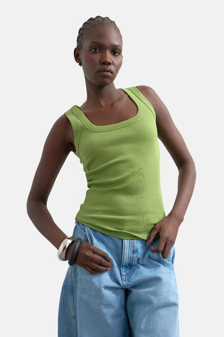 Débardeur vert TOPSHOP à texture côtelée, porté avec un jean et un bracelet argenté.