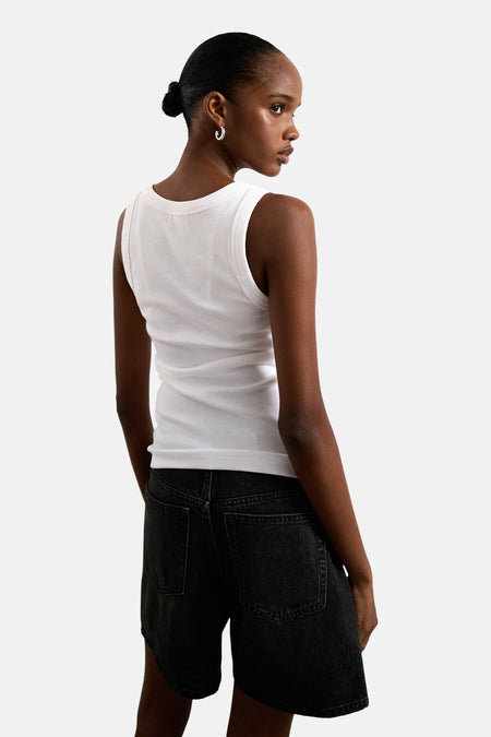 Witte tanktop van TOPSHOP, met geribbelde textuur, gecombineerd met zwarte denim shorts.