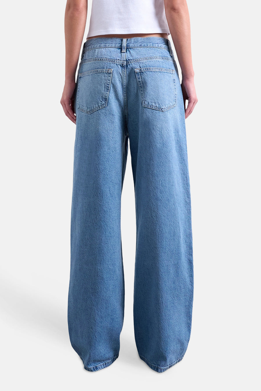 Rechte jeans van mid-blauwe denim van TOPSHOP, met wijde pijpen, twee achterzakken en een witte crop top.
