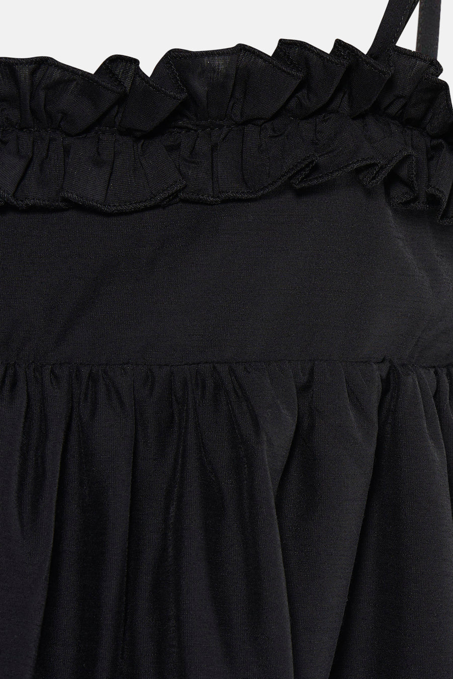 Détail d'une robe noire TOPSHOP avec volants sur le dessus et tissu plissé.
