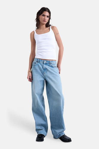 Débardeur blanc de TOPSHOP, porté avec un jean ample et des mocassins noirs.