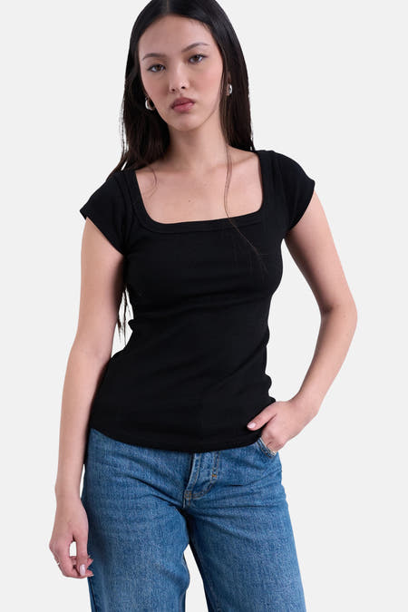 T-shirt noir à manches courtes de TOPSHOP, avec un décolleté carré, porté avec un jean bleu.