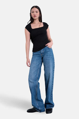 T-shirt noir à manches courtes de TOPSHOP, avec un décolleté carré, associé à un jean bleu ample et des chaussures noires.