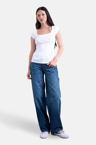 T-shirt blanc à manches courtes de TOPSHOP, avec un décolleté carré et porté avec un jean ample.