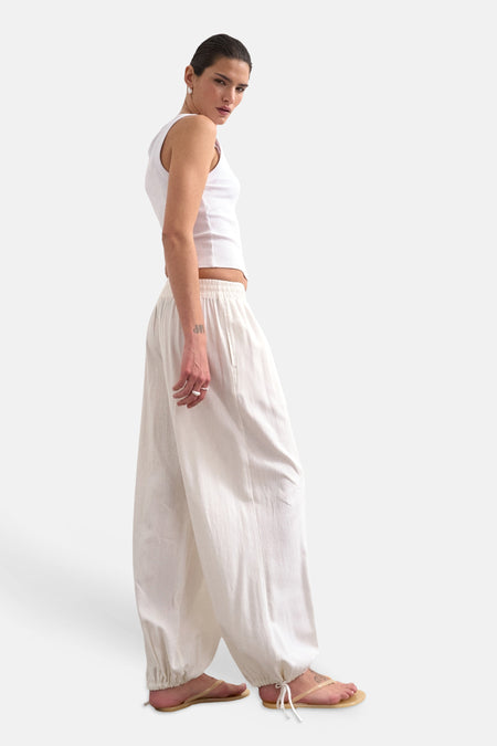 Witte wijde broek van TOPSHOP met elastische tailleband en enkelboorden, gedragen door model in zijprofiel.