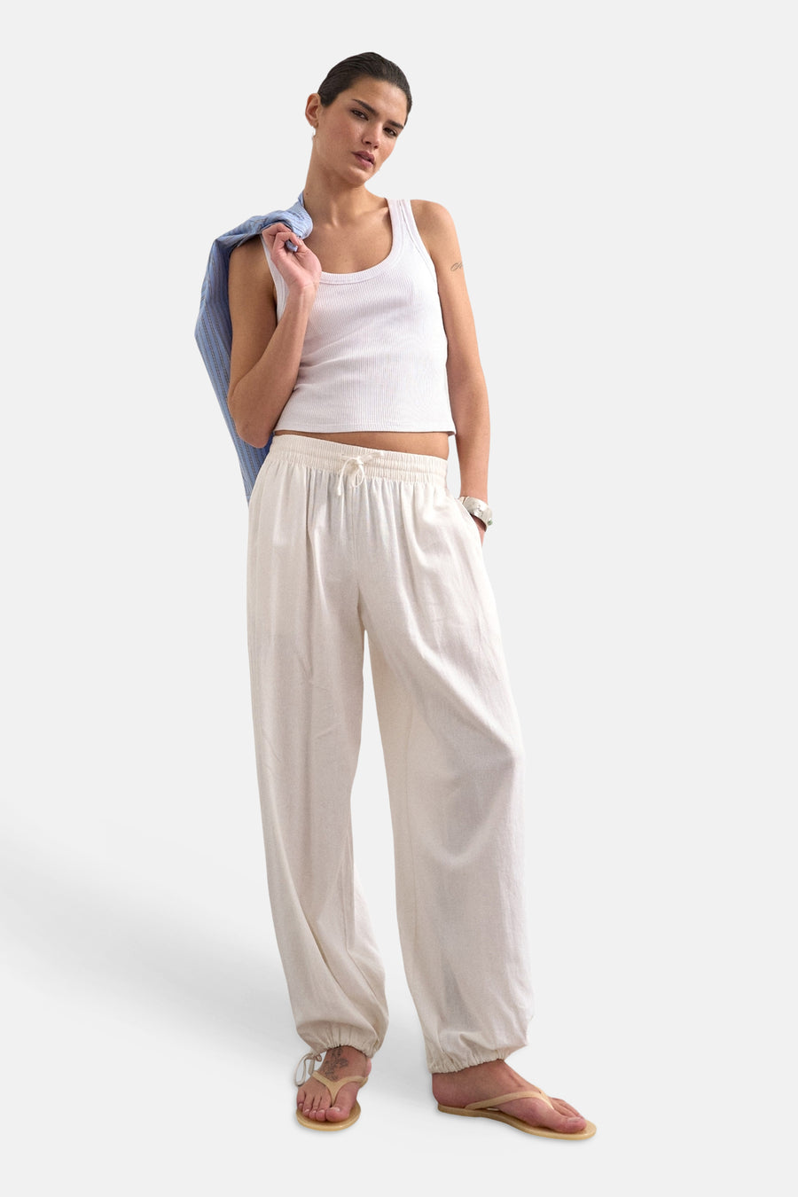 Witte losvallende broek van TOPSHOP met trekkoord in de taille en elastische zomen, gedragen met een wit hemdje en teenslippers.