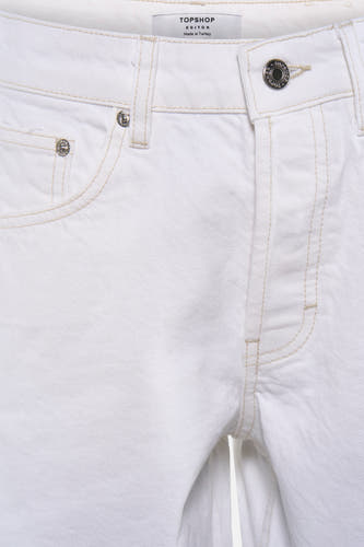 Short blanc TOPSHOP avec surpiqûres contrastées, boutons métalliques et texture denim tissée, gros plan.