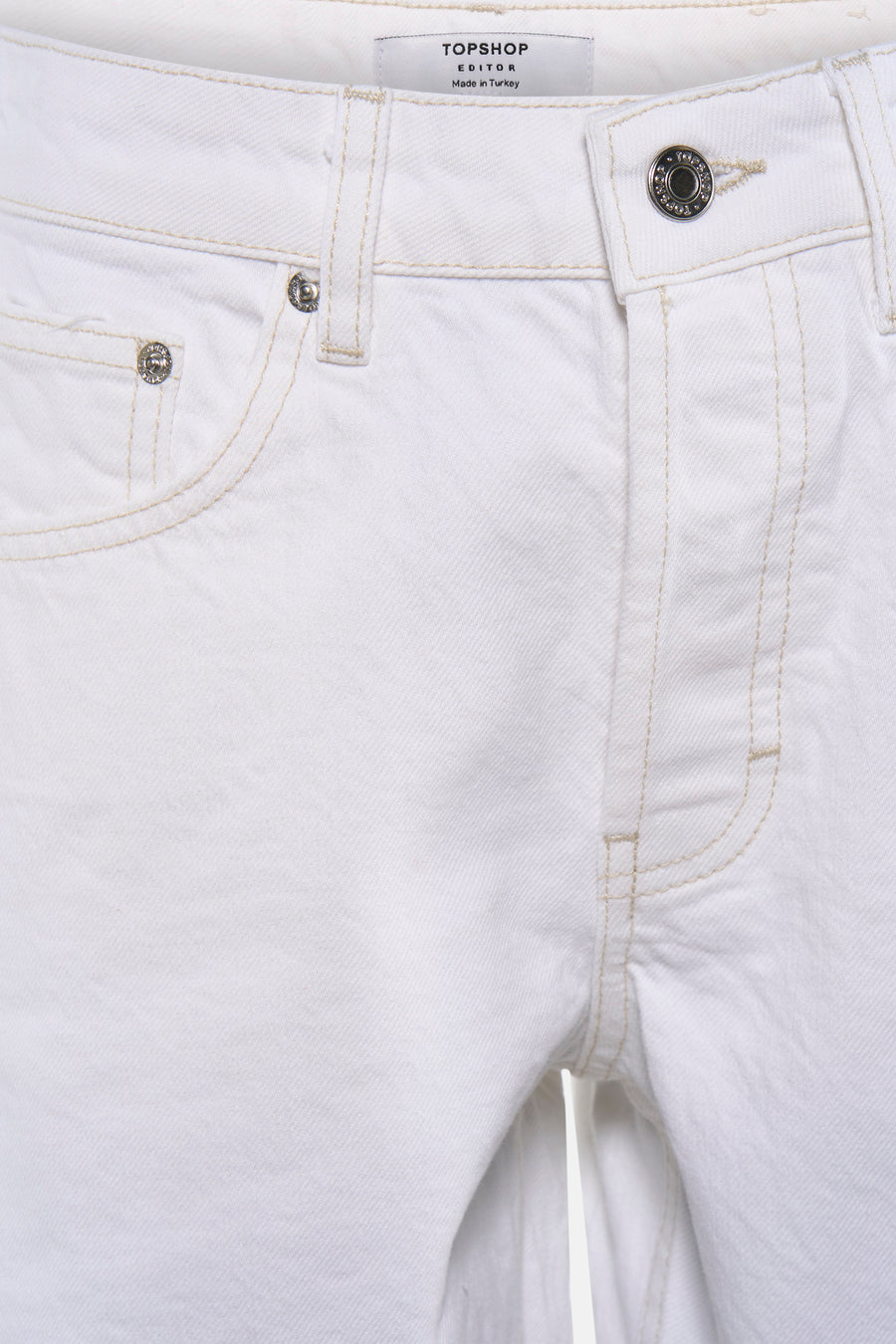 Short blanc TOPSHOP avec surpiqûres contrastées, boutons métalliques et texture denim tissée, gros plan.