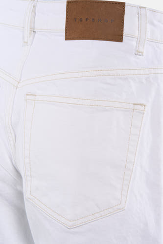 Short en jean blanc de TOPSHOP avec surpiqûres marron clair, une poche arrière et une étiquette de marque sur la ceinture.
