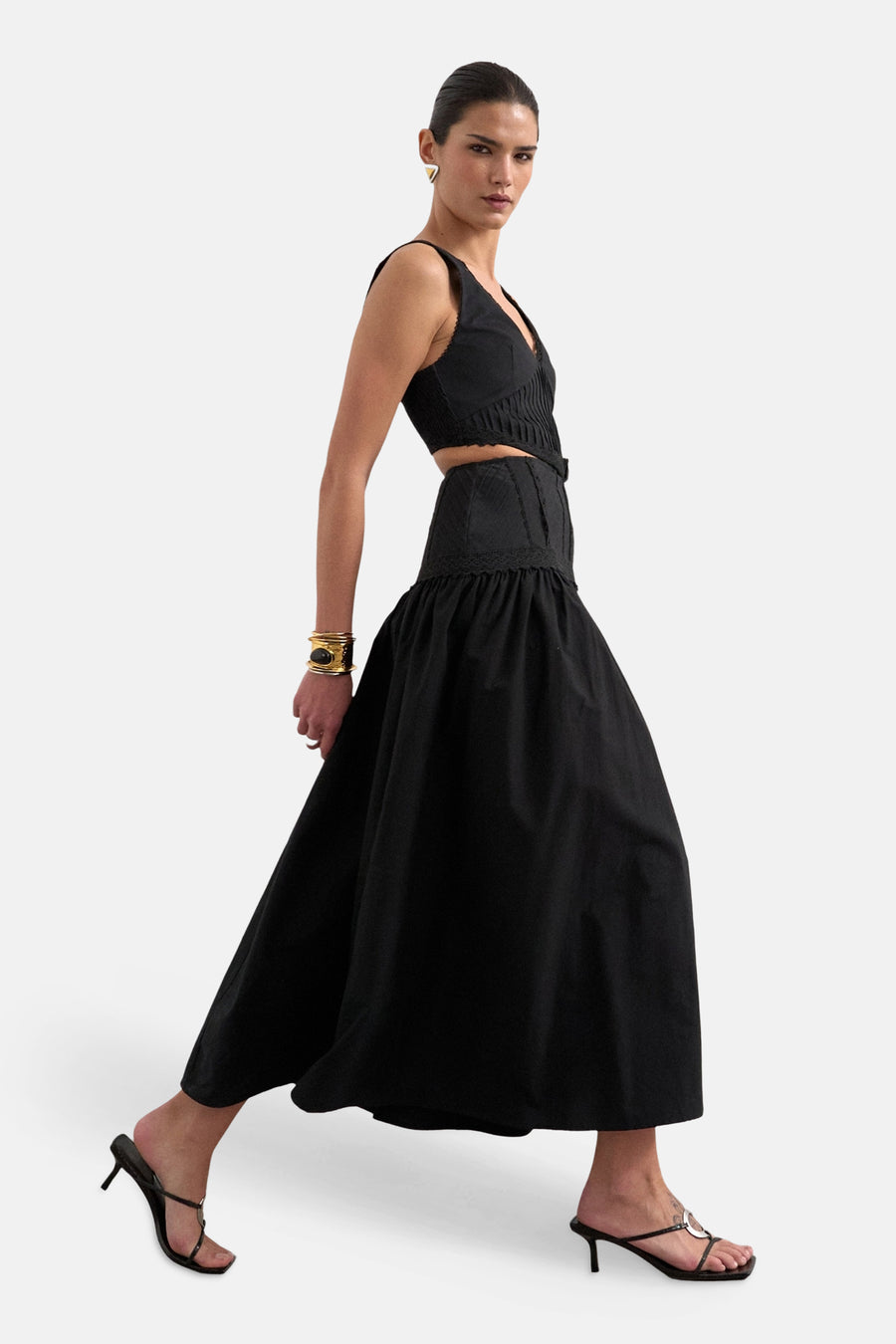 Robe noire sans manches TOPSHOP avec encolure en V en dentelle et détails plissés, taille cintrée, portée par un mannequin avec un bracelet doré.