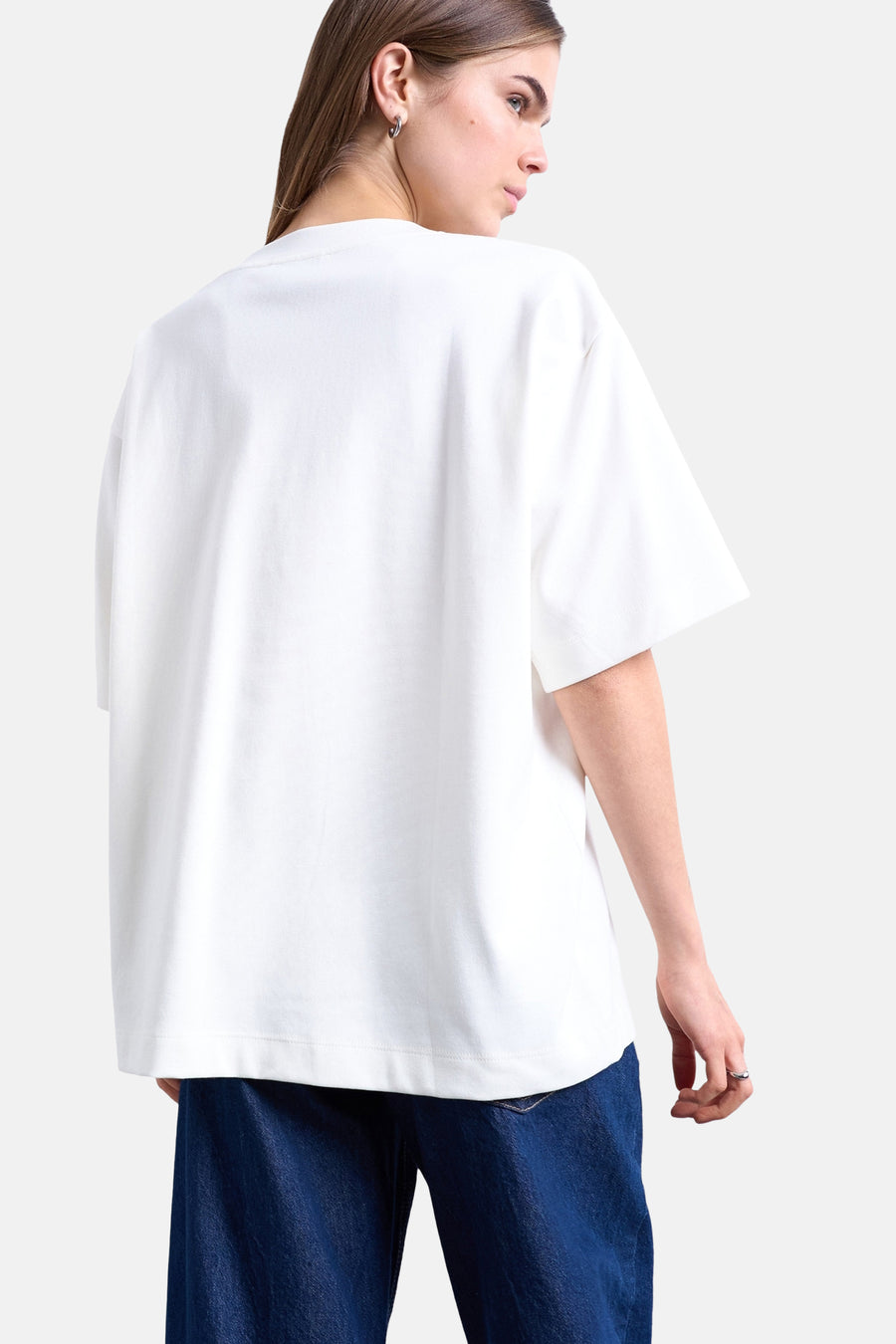 T-shirt écru TOPSHOP coupe oversize à manches courtes, dos du mannequin en jean bleu foncé.