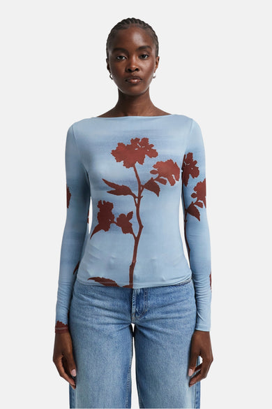 T-shirt bleu à manches longues de TOPSHOP, avec un motif floral marron, porté avec un jean bleu.