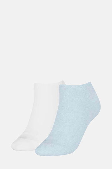 Chaussettes bleues de TOMMY JEANS, avec une chaussette blanche en arrière-plan.
