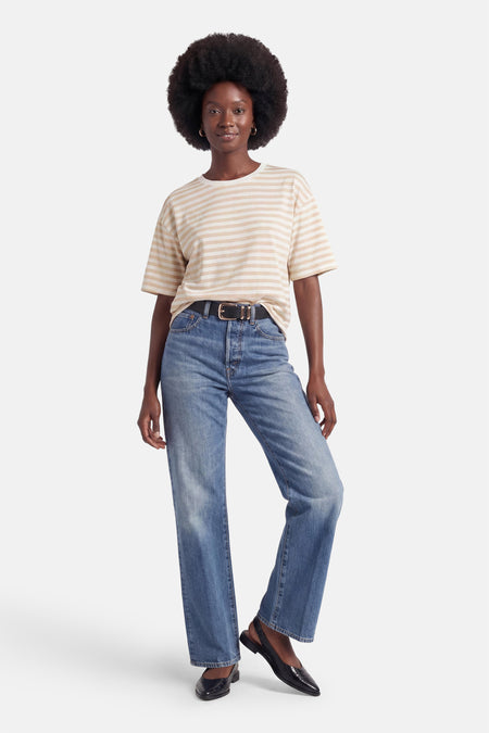 T-shirt beige et blanc à rayures de Terra di Siena à manches courtes, porté par un mannequin avec un jean.