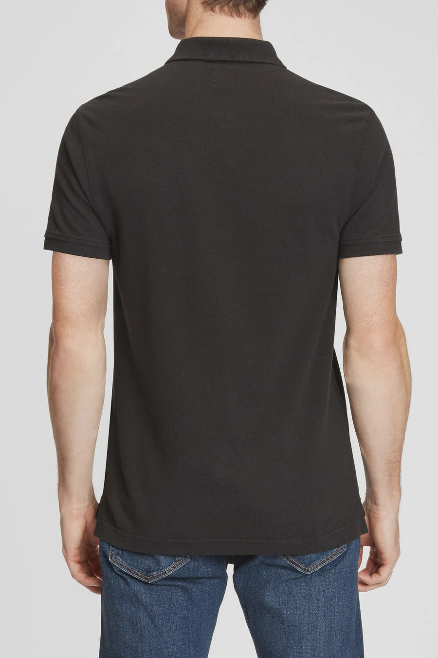 Polo noir à manches courtes de Levi's, vu de l'arrière, porté avec un jean bleu.