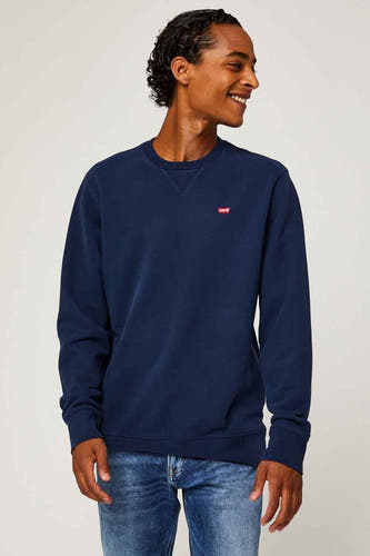 Sweater bleu de Levi's®, vu de de dos, porté avec un pantalon en cuir.