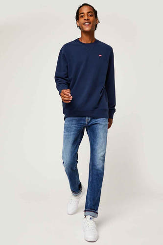 Pull-over bleu de Levi's®, porté avec des jeans et des baskets blanches.