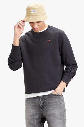 Pull-over noir de Levi's avec petit logo sur la poitrine, porté avec un chapeau panier beige.