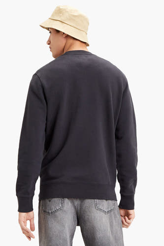 Zwarte sweater van Levi's, rug aanzicht, gecombineerd met een lichte jeans en beige bucket hat.
