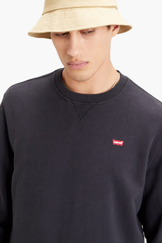 Zwarte sweater van Levi's met klein logo op de borst, gedragen met een beige bucket hat.
