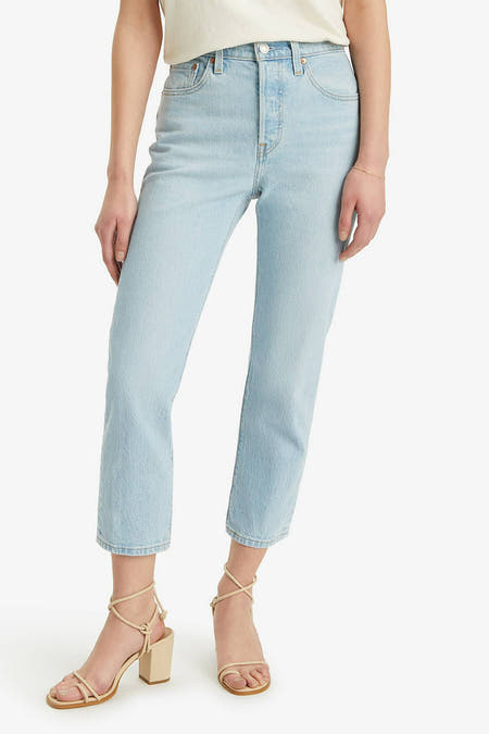 Jean droit bleu clair de Levi's, vu de derrière, associé à un t-shirt crème et des baskets beige.