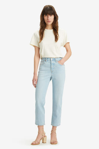 Jean en denim bleu clair droit de Levi's, porté avec un t-shirt crème et des sandales à talon.