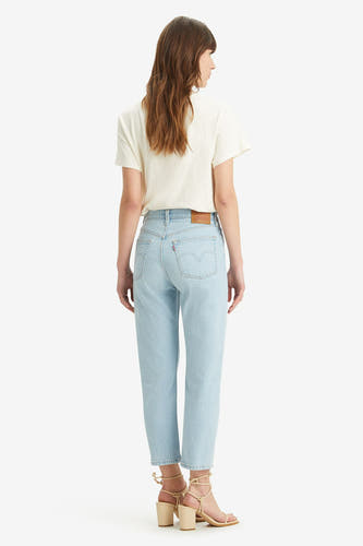 Lichtblauwe rechte jeans van Levi's, gezien van achteren, gecombineerd met een crèmekleurig t-shirt en beige hakken.
