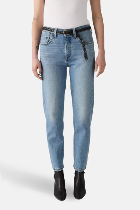 Jean droit en denim bleu clair de Levi's®, porté avec un haut blanc et des bottes noires, en vue latérale.