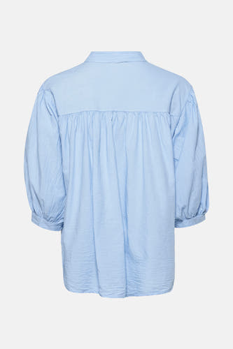 Chemise bleue à longues manches de Terra di Siena, avec une texture froissée et des plis sur le dos.
