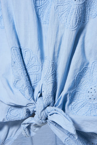 Chemise bleue à manches longues de Terra di Siena, avec des motifs de fleurs brodés et un détail de boutons.