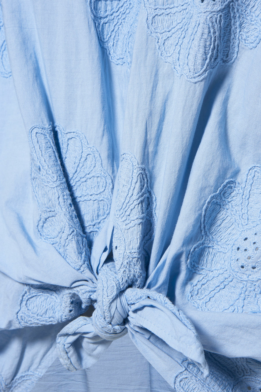 Chemise bleue à manches longues de Terra di Siena, avec des motifs de fleurs brodés et un détail de boutons.