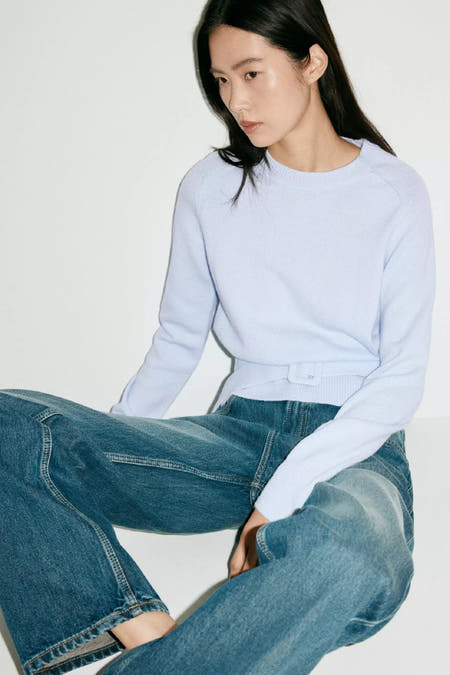 Lichtblauwe ronde hals trui van MANGO, fijn gebreid, met riemdetail, lifestyle shot model in jeans
