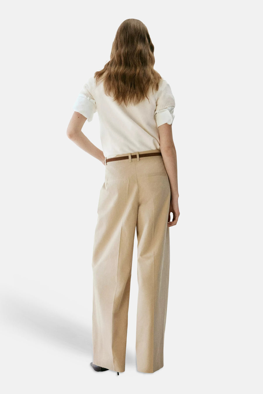 Ecru korte mouwen pull van MANGO, achterzijde, met geribbelde mouwuiteinden en strakke pasvorm, gedragen met beige broek en bruine riem