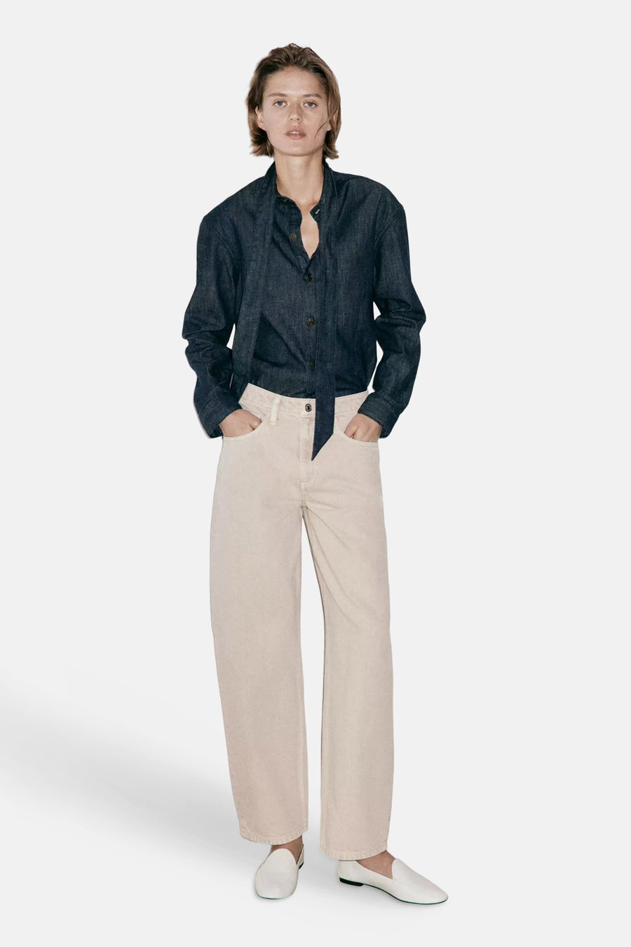 Beige 5-pocket broek van MANGO, rechte pasvorm, lichte stof, model met donkerblauw overhemd en witte loafers, front view