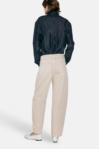 Beige 5-pocket broek van MANGO, achterzijde weergegeven met rechte pasvorm en witte schoenen.
