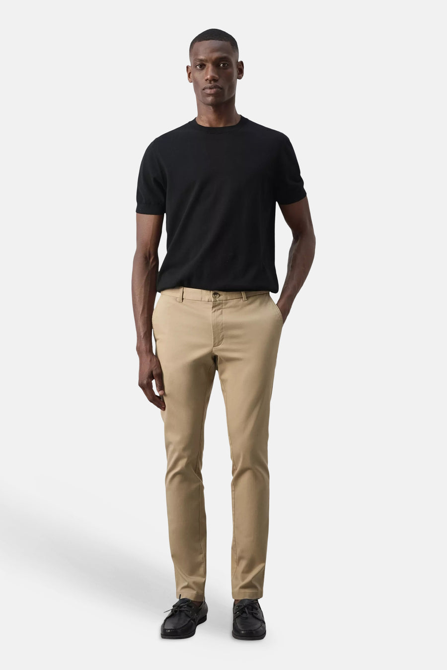 Beige chino broek van MANGO, strak model, gedragen met zwart T-shirt en zwarte schoenen, front view