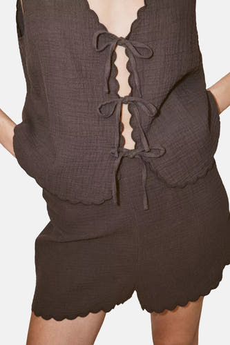 Bruine mouwloze blouse van MANGO met scalloped rand en voorzijde strikken, gekreukt textuur, close-up vooraanzicht