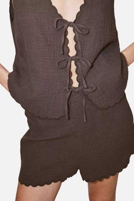Bruine mouwloze blouse van MANGO met scalloped rand en voorzijde strikken, gekreukt textuur, close-up vooraanzicht
