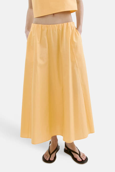 Gele casual rok van MANGO met elastische taille, vloerlange A-linie, gedragen met gele crop top en zwarte sandalen, front view