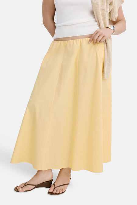 Gele casual rok van MANGO, met elastische taille en vloeiende A-linie, gedragen met wit topje en bruine sandalen, front view