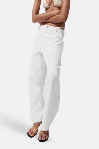 Witte rechte jeans van denim met zakken van MANGO, gedragen met een beige bikinitop en sandalen, zijprofiel.