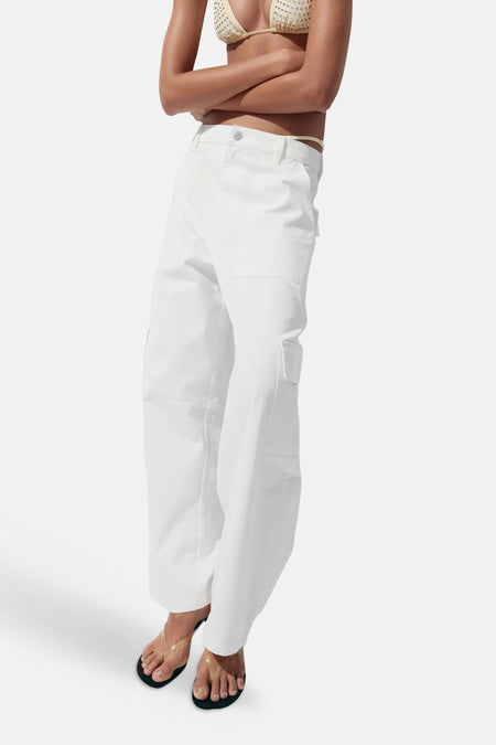 Witte rechte jeans van denim met zakken van MANGO, gedragen met een beige bikinitop en sandalen, zijprofiel.