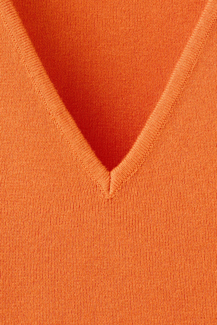 Oranje gebreide debardeur van MANGO, close-up van V-hals met fijne textuur