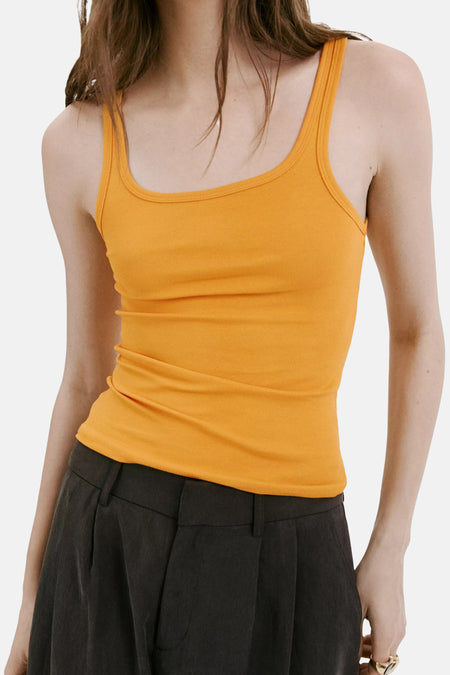Oranje tanktop met ruches aan de zijkant van MANGO, gedragen met donkere broek, close-up voorzijde