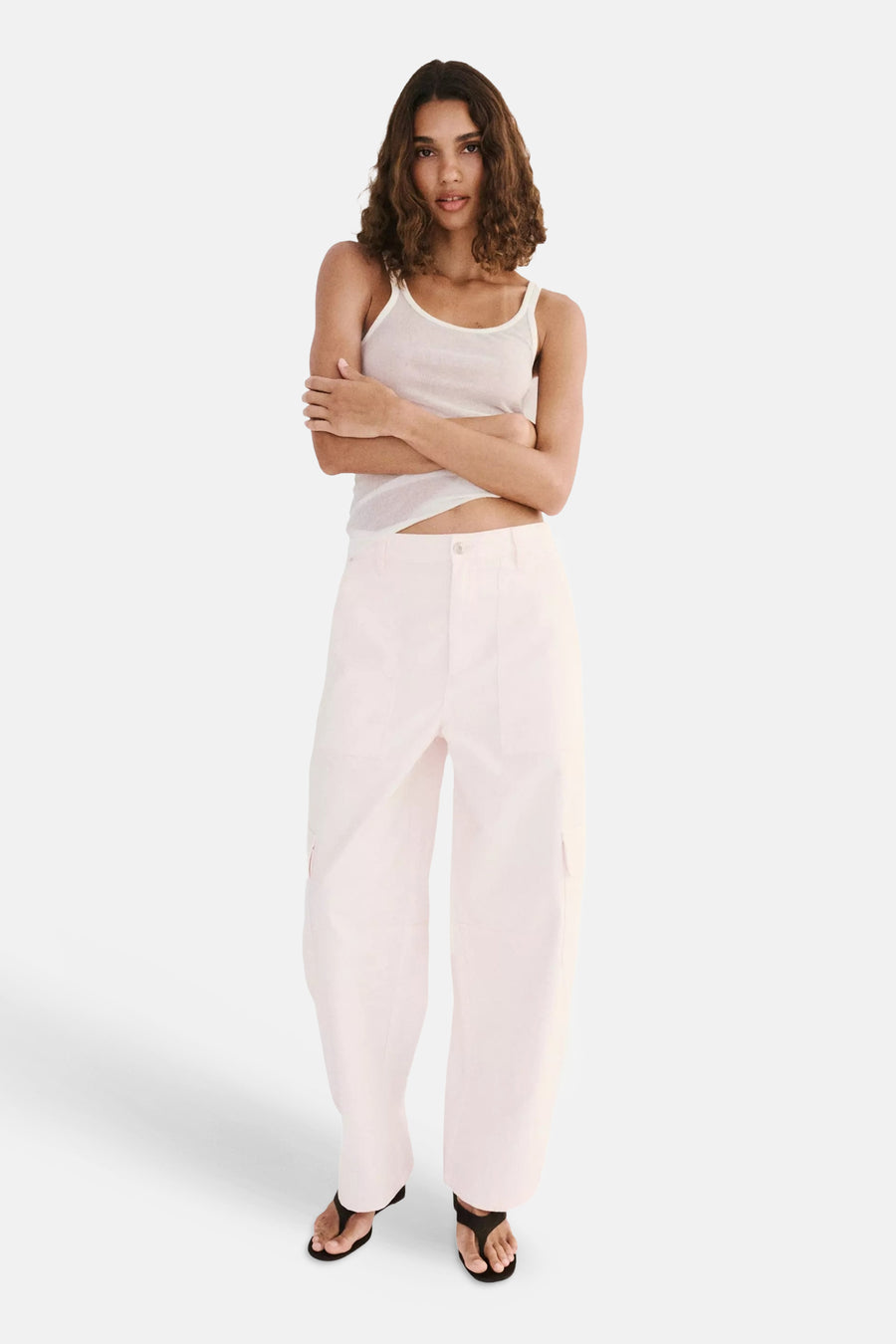 Roze cargobroek van MANGO, lichte stof, wijde pasvorm, voorzijde met zakken, model in full length pose met wit topje en sandalen