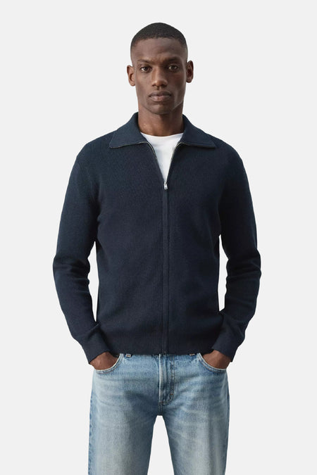 Blauwe gebreide gilet met rolkraag en rits van MANGO, gedragen over wit T-shirt, voorzijde weergave
