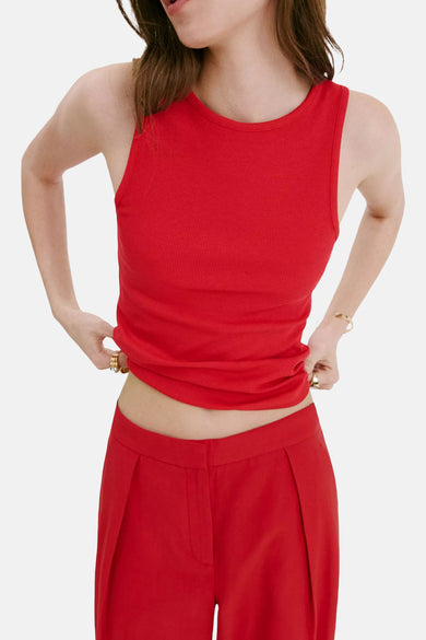 Rode ribbel tanktop van MANGO, strak model met ronde hals, gekreukt detail aan onderkant, lifestyle shot vanaf borst tot heup