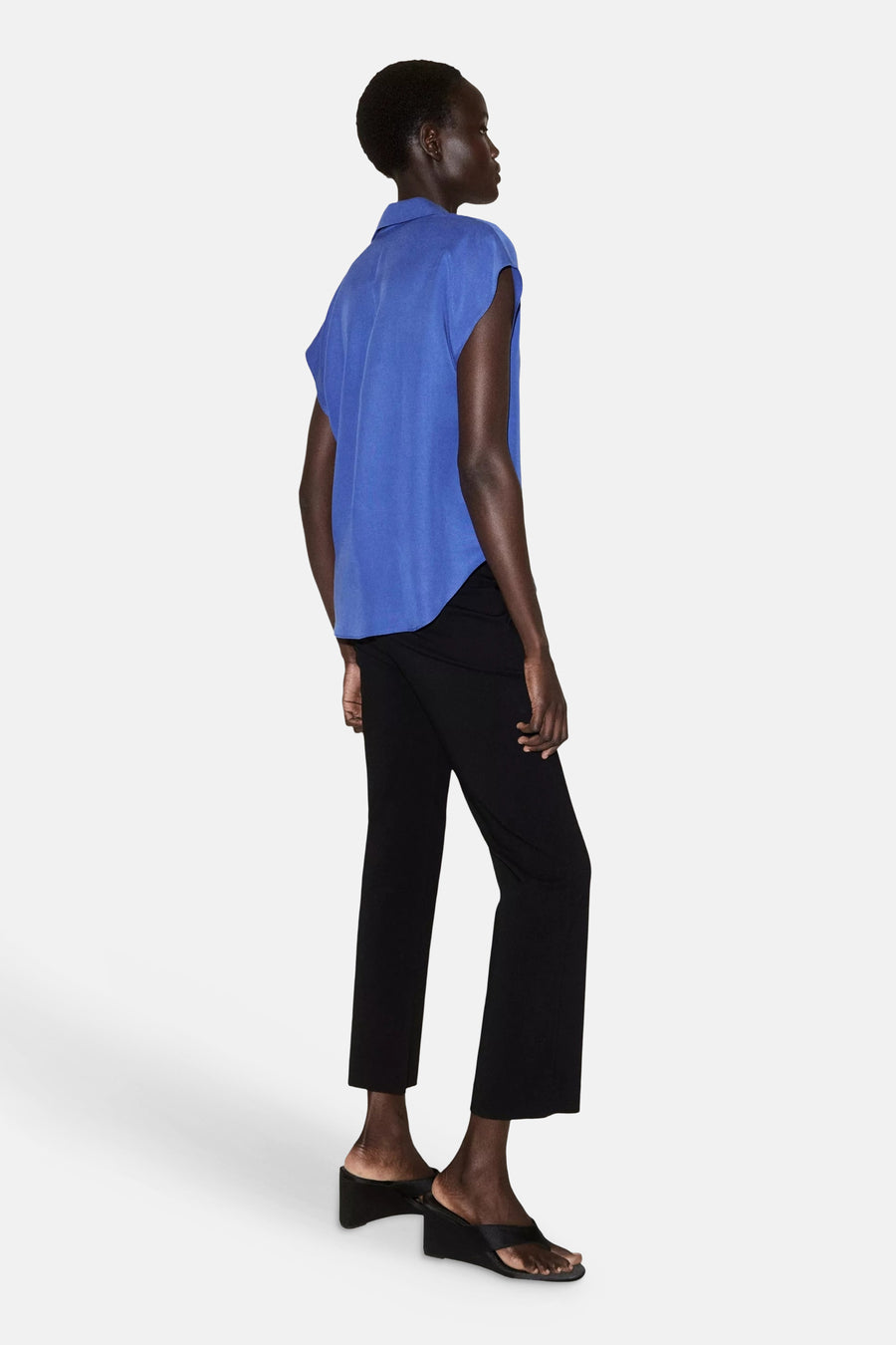 Blauw mouwloos hemd van MANGO, zijwaarts, met klassieke kraag en vloeiende stof, gedragen met zwarte broek en plateau sandalen