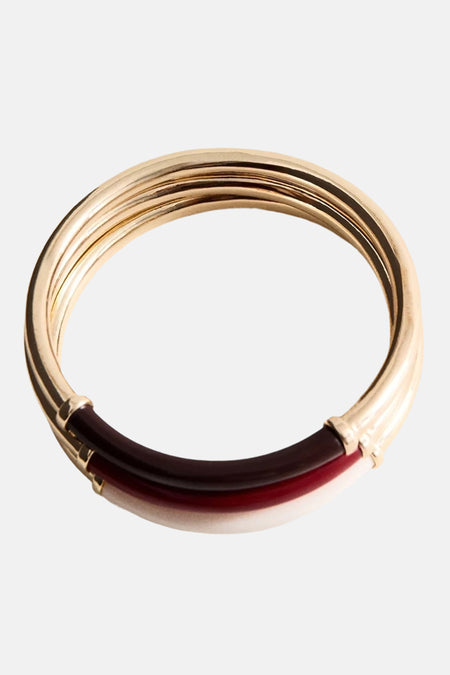Multicolor armband van goudkleurig metaal met rode en crèmekleurige accenten, van MANGO, gestileerd in close-up weergave